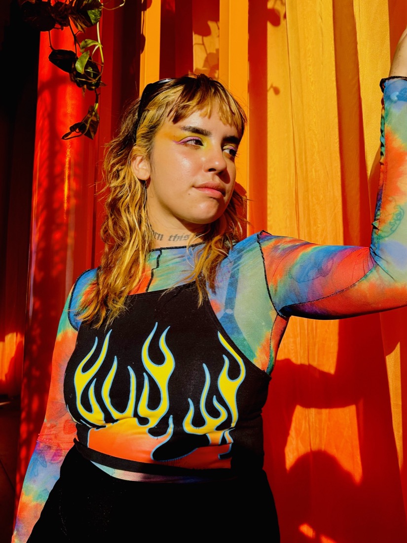 Frida con remera de llamas y luz naranja