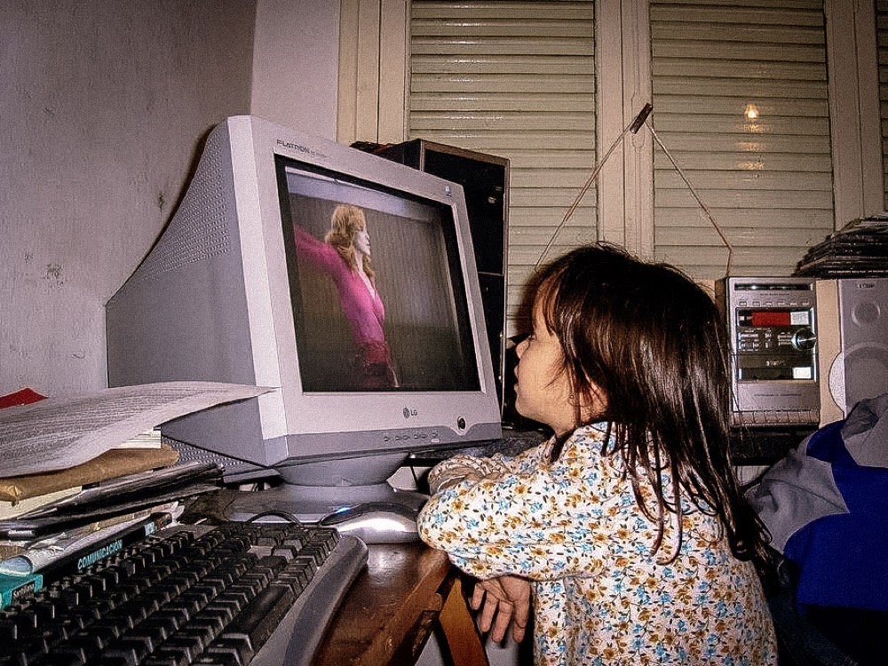 Frida de chica mirando a Madonna en una compu vieja